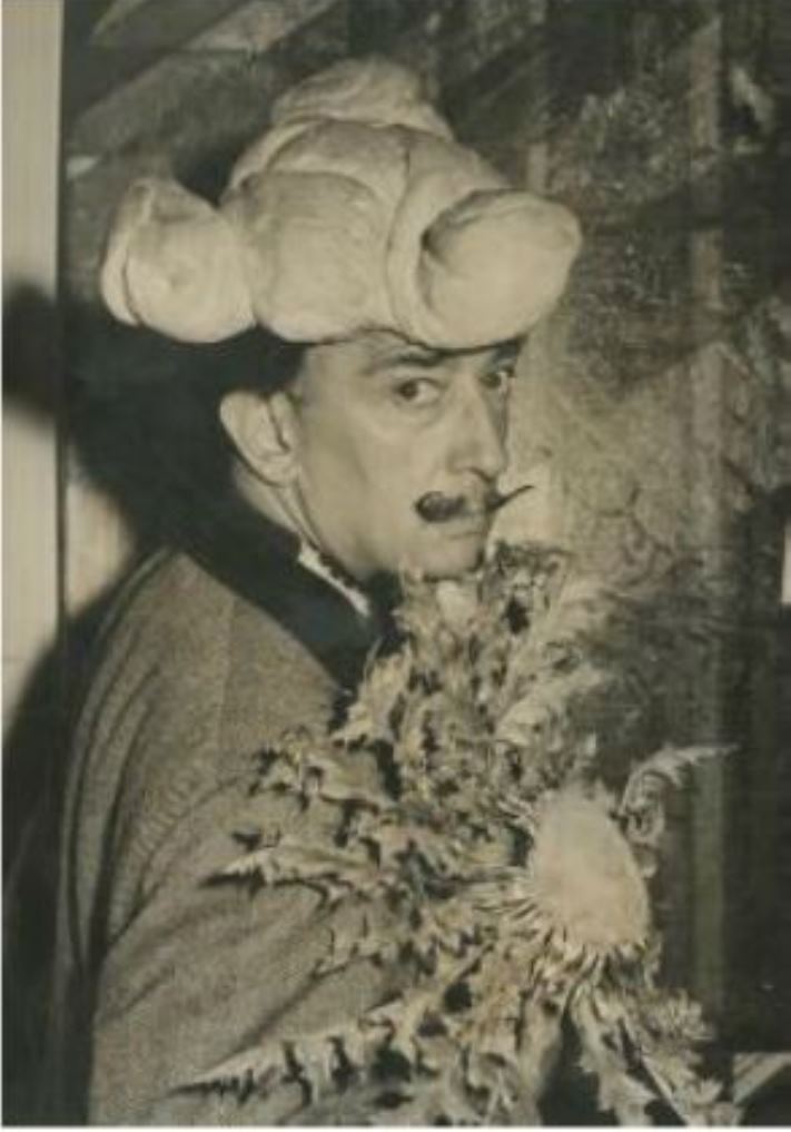 Salavador Dali coiffé d'un chapeau de pain et tenant un tournesol 1958