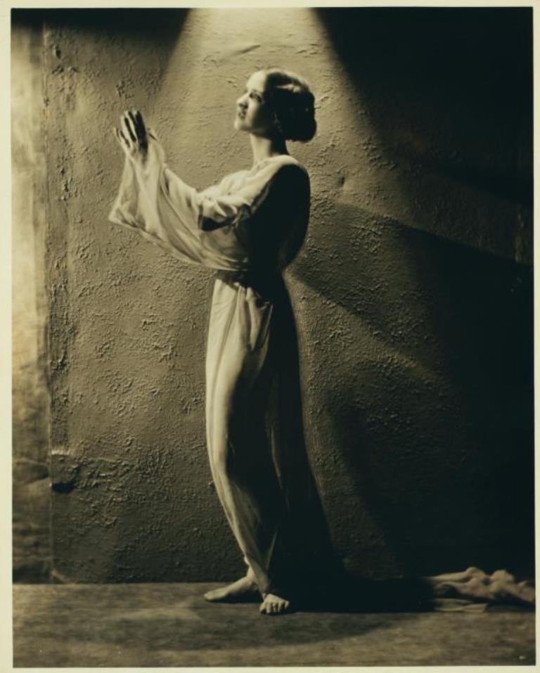 Nickolas Muray. Isadora Duncan in costume, standing in a halo of light, hands lifted as if in prayer Via nypl